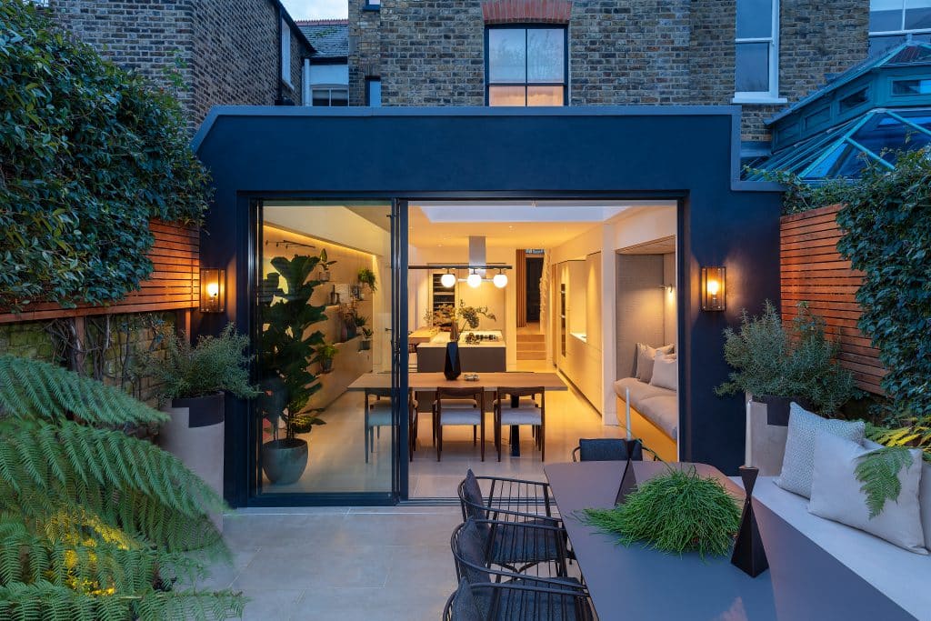 Garden view of a modern style dining room and kitchen.