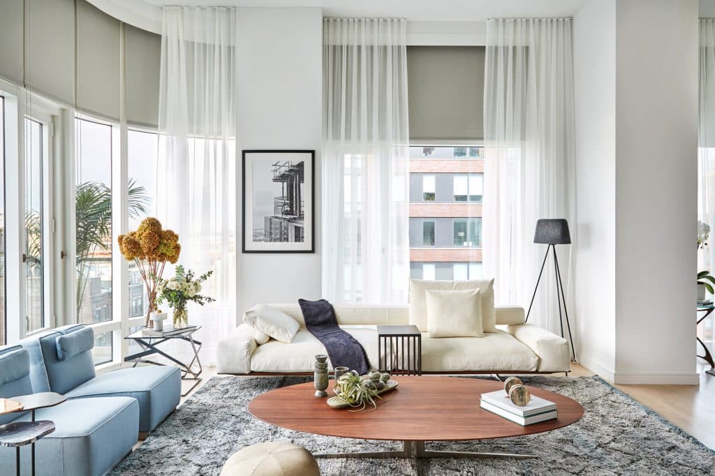 Beautiful natural light filled living room of a penthouse. Neutral tones are filling in the whole space giving the living room a calm atmosphere.