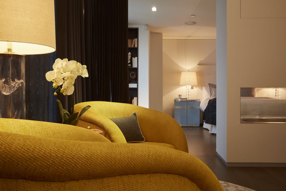 A pair of collectors armchairs create a soft seating area in this principle bedroom suite. 