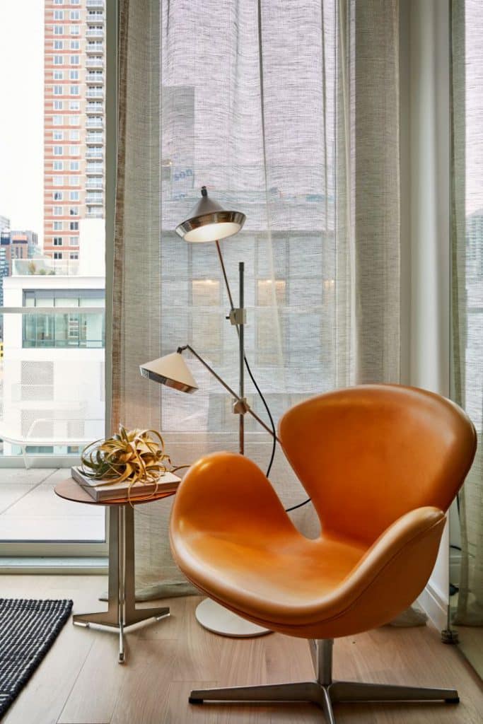 A leather Swan chair from Fritz Hansen sits in the corner of this bedroom.