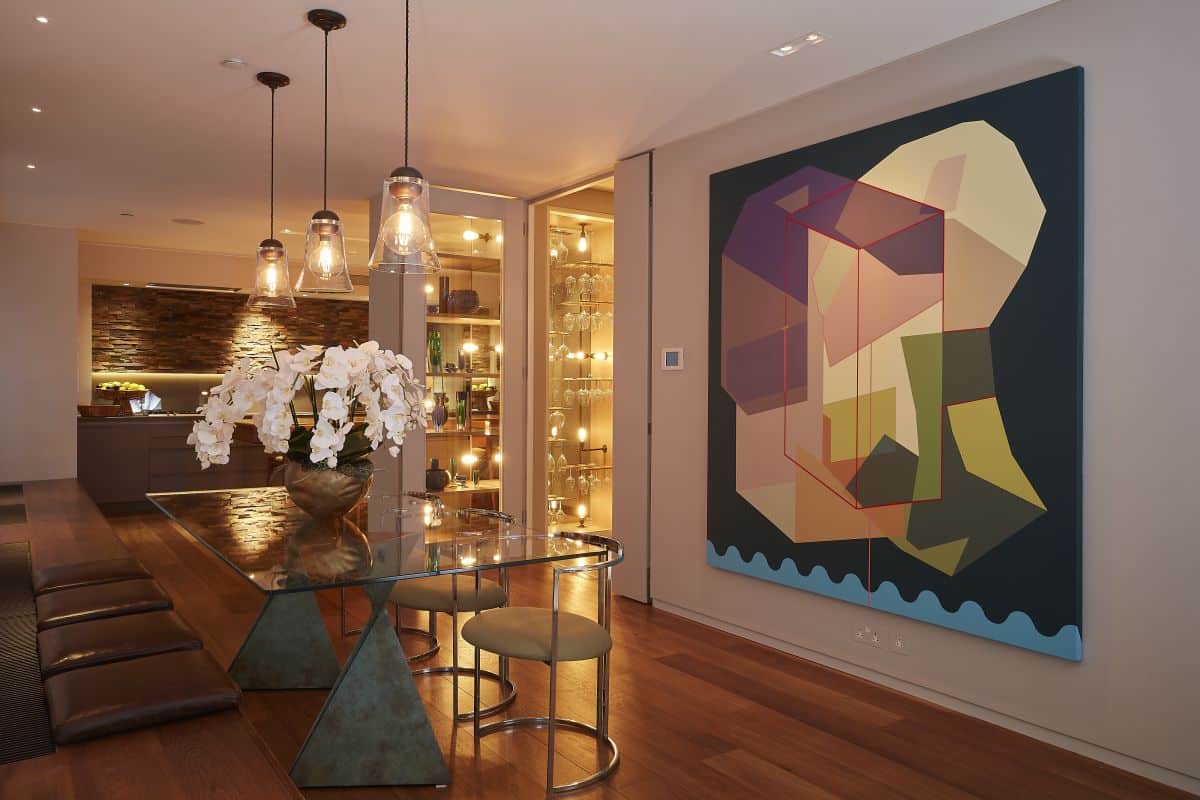 Wine glasses displayed in warmly lit dining and kitchen area. 