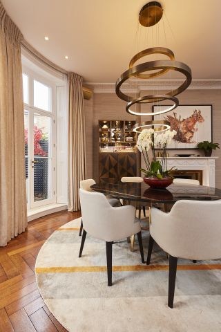 A image of round marble dining table in a french door bay window in a London period property.