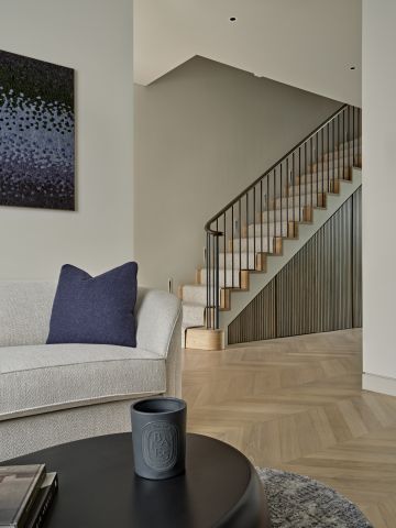 Open plan living room, entrance and hallway with staircase in back.