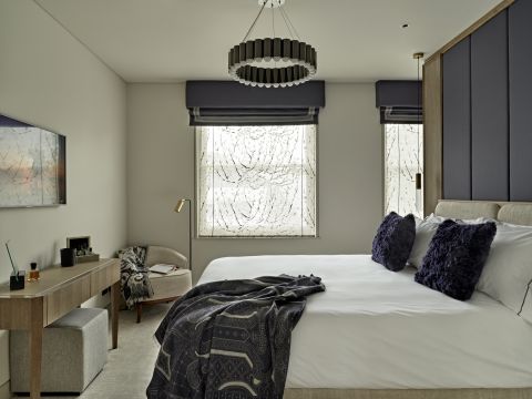 Master bedroom in which the neutral tones are mixed up with navy blue accessories.