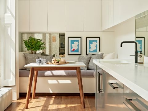 White and grey galley kitchen with high ceilings and sash windows.