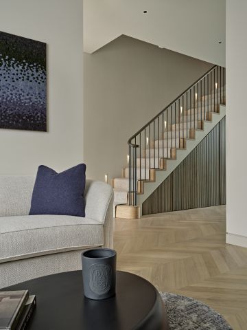 Open plan living entrance hallway with a staircase in the back and a living room in front.