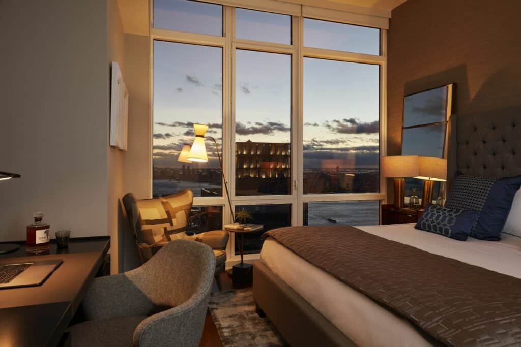 A masculine designed penthouse bedroom at night.