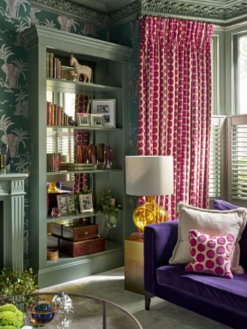 Green living room with pops of colour in furniture and curtains.