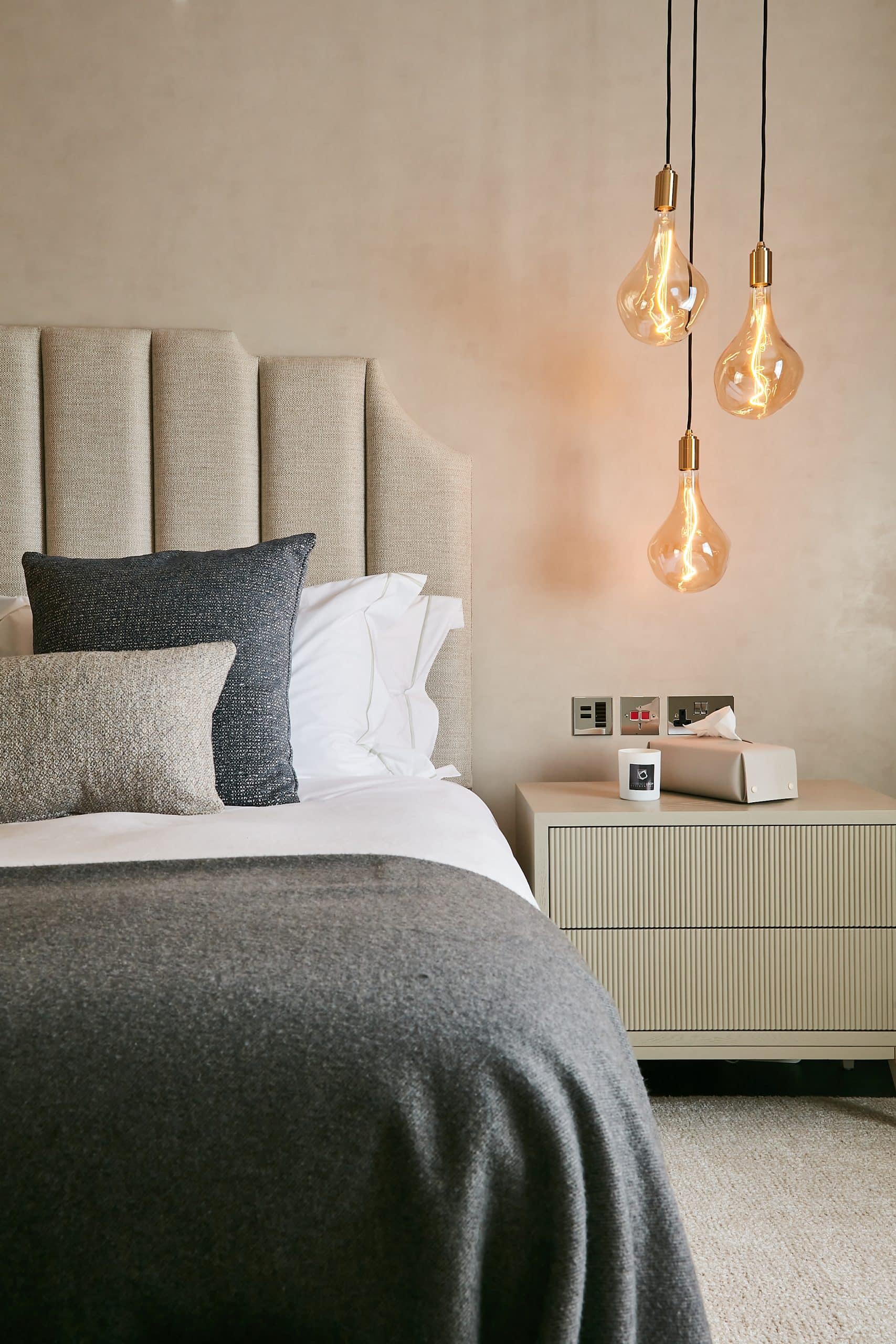 Pendant lights giving a more elevated look to neutral bed.