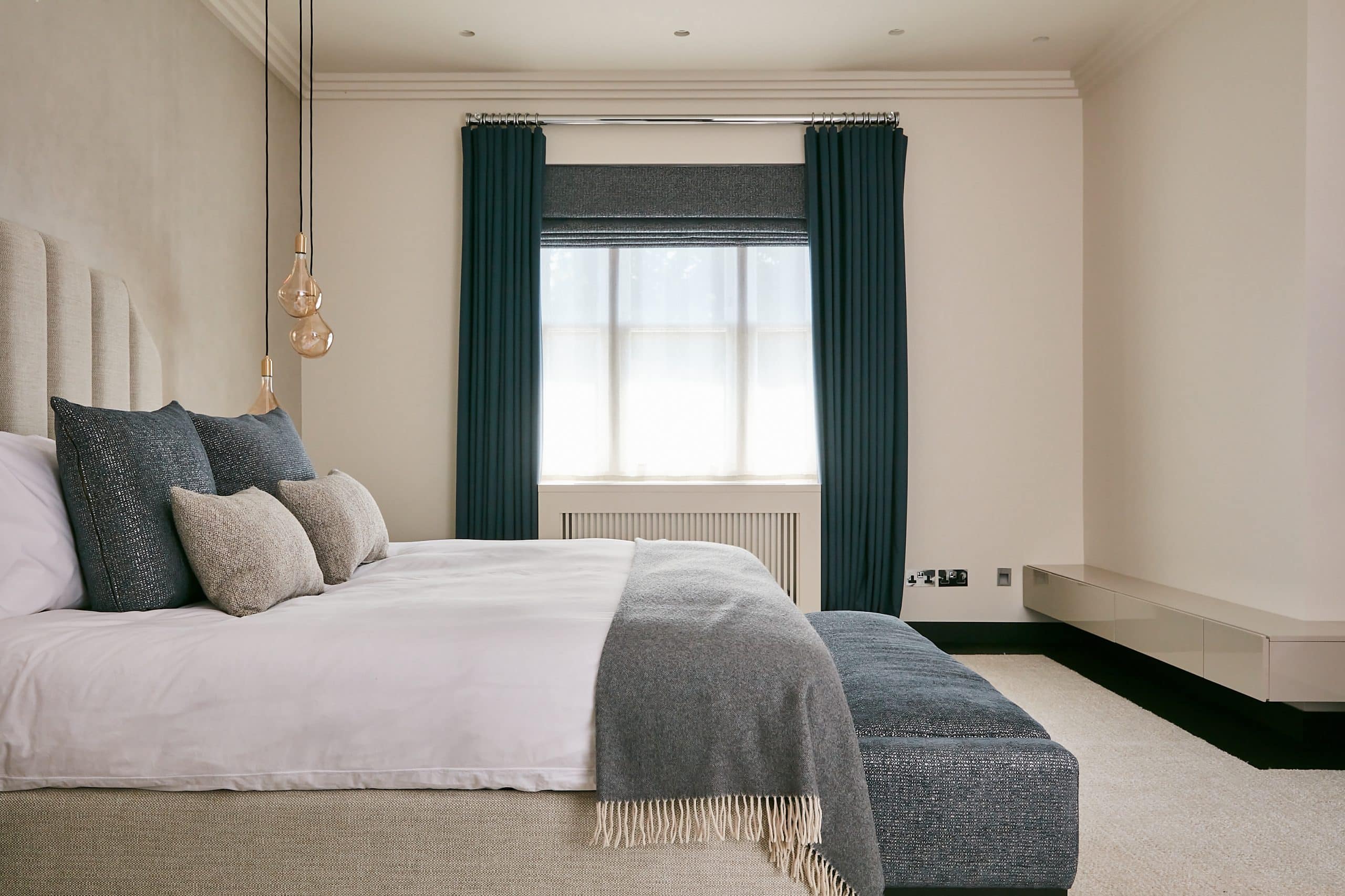 Neutral principle bedroom with greyish-blue textiles.