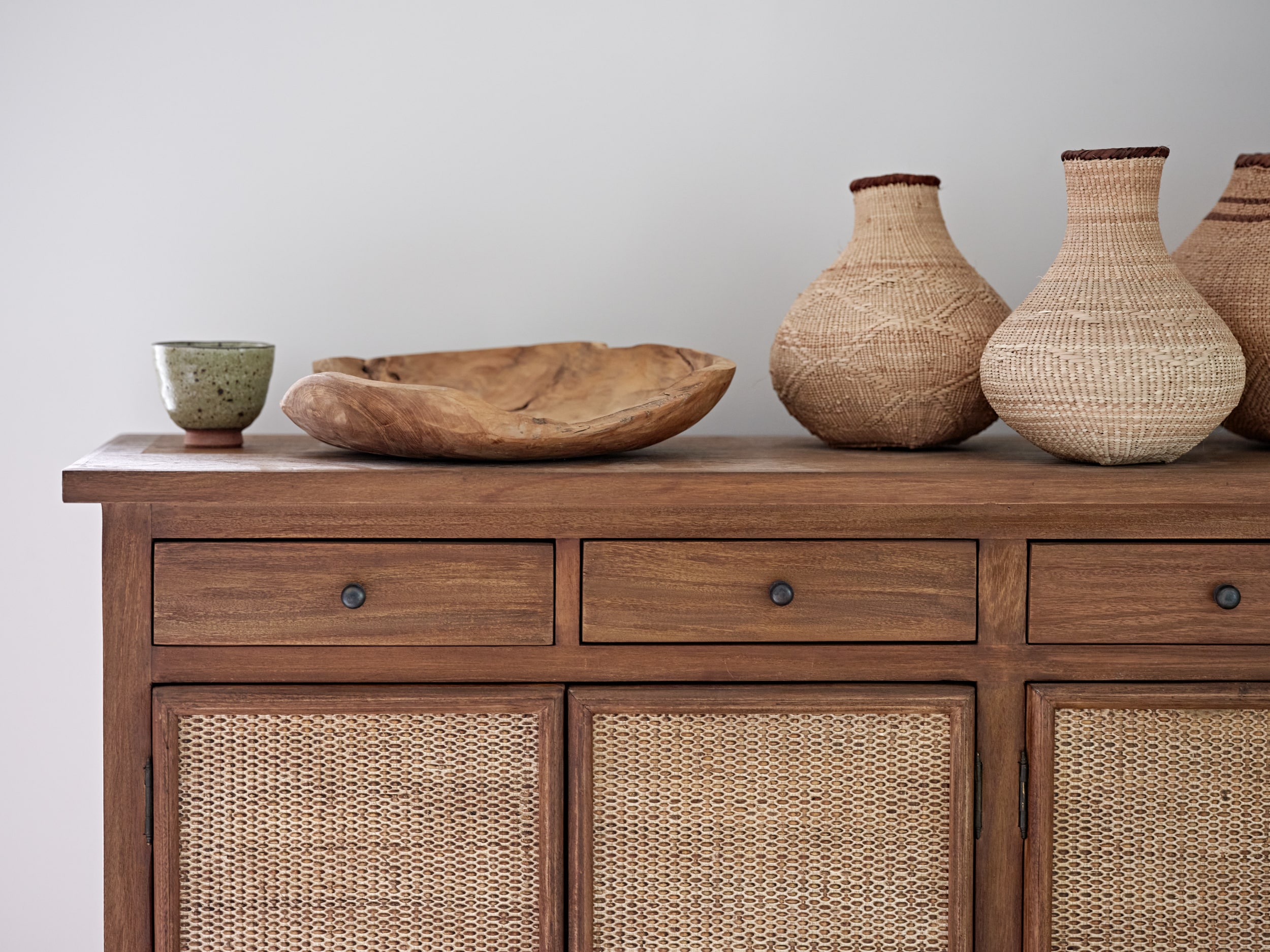 Wooden cabinetry with rattan front panels.