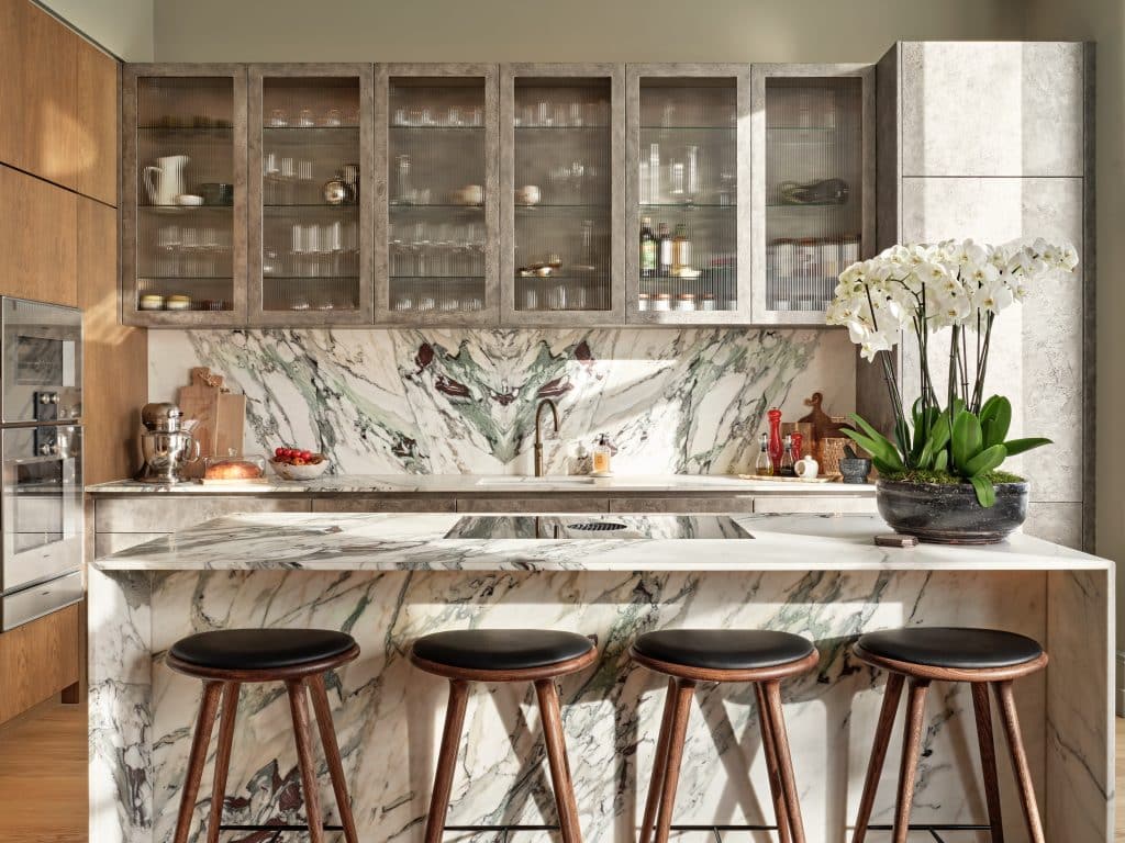 Beautiful marble kitchen with bespoke cabinetry. In the cabinetry a wine fridge, steam oven and regular oven is situated.