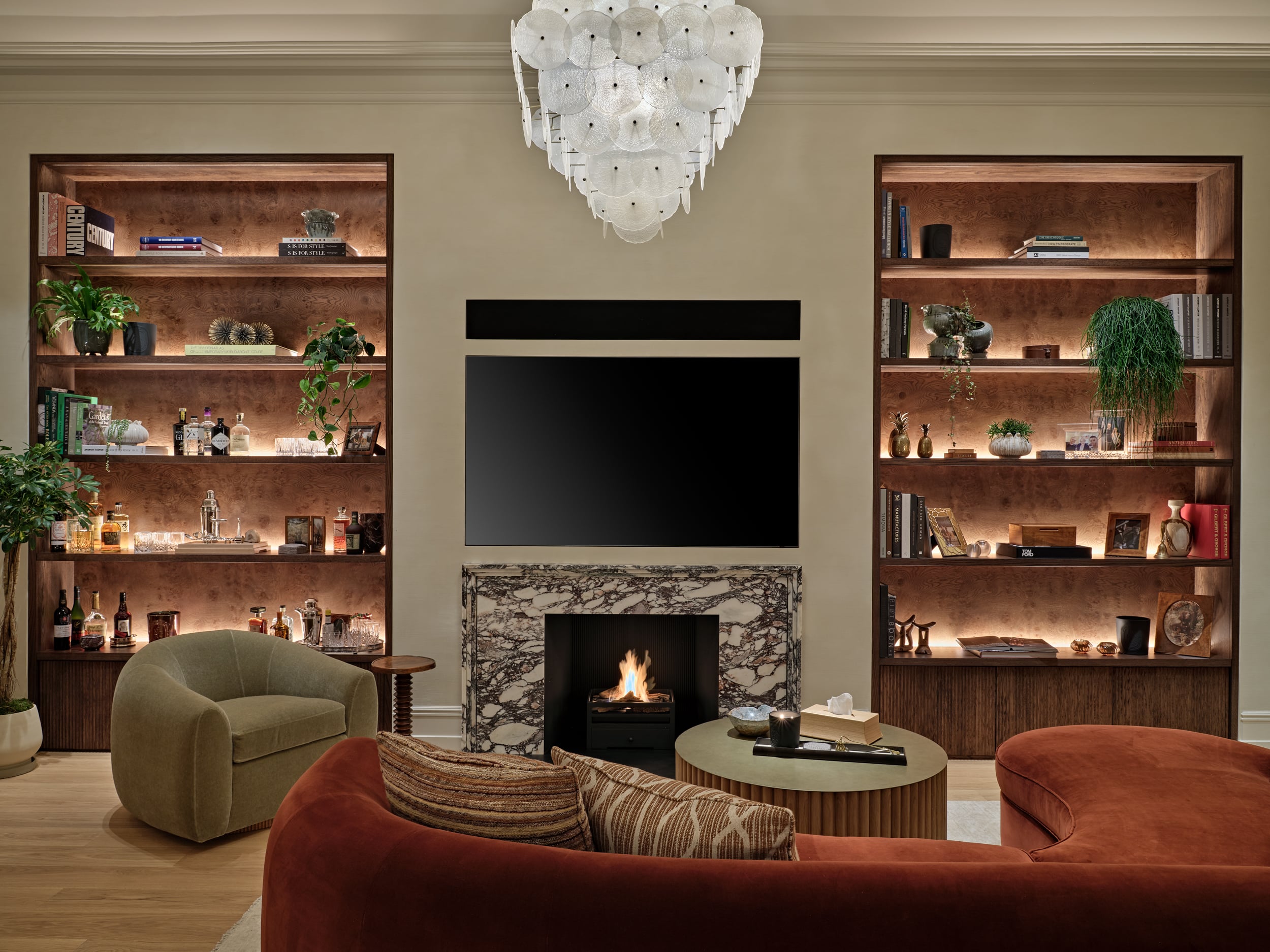 Cozy living space in Central London apartment.On the two sides of the TV and Fireplace there are bespoke shelves displaying sentimental items lovingly collected by the owner.