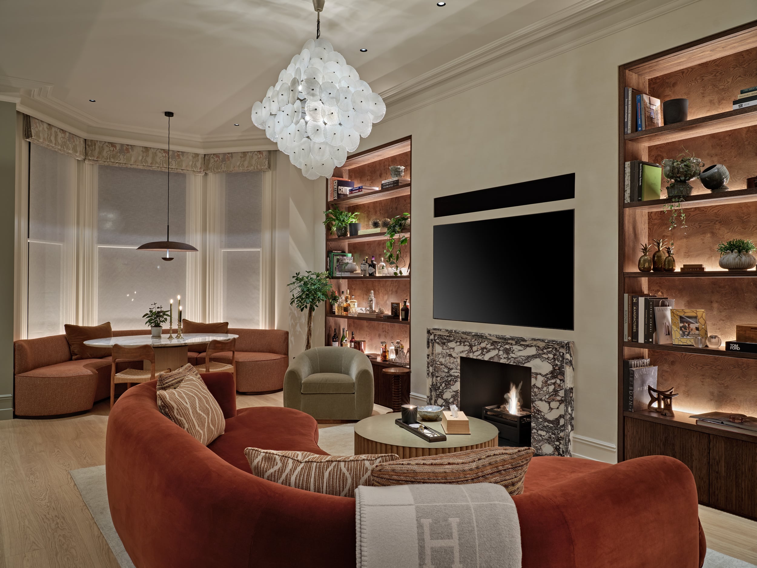 Cozy living space in Central London apartment.On the two sides of the TV and Fireplace there are bespoke shelves displaying sentimental items lovingly collected by the owner.