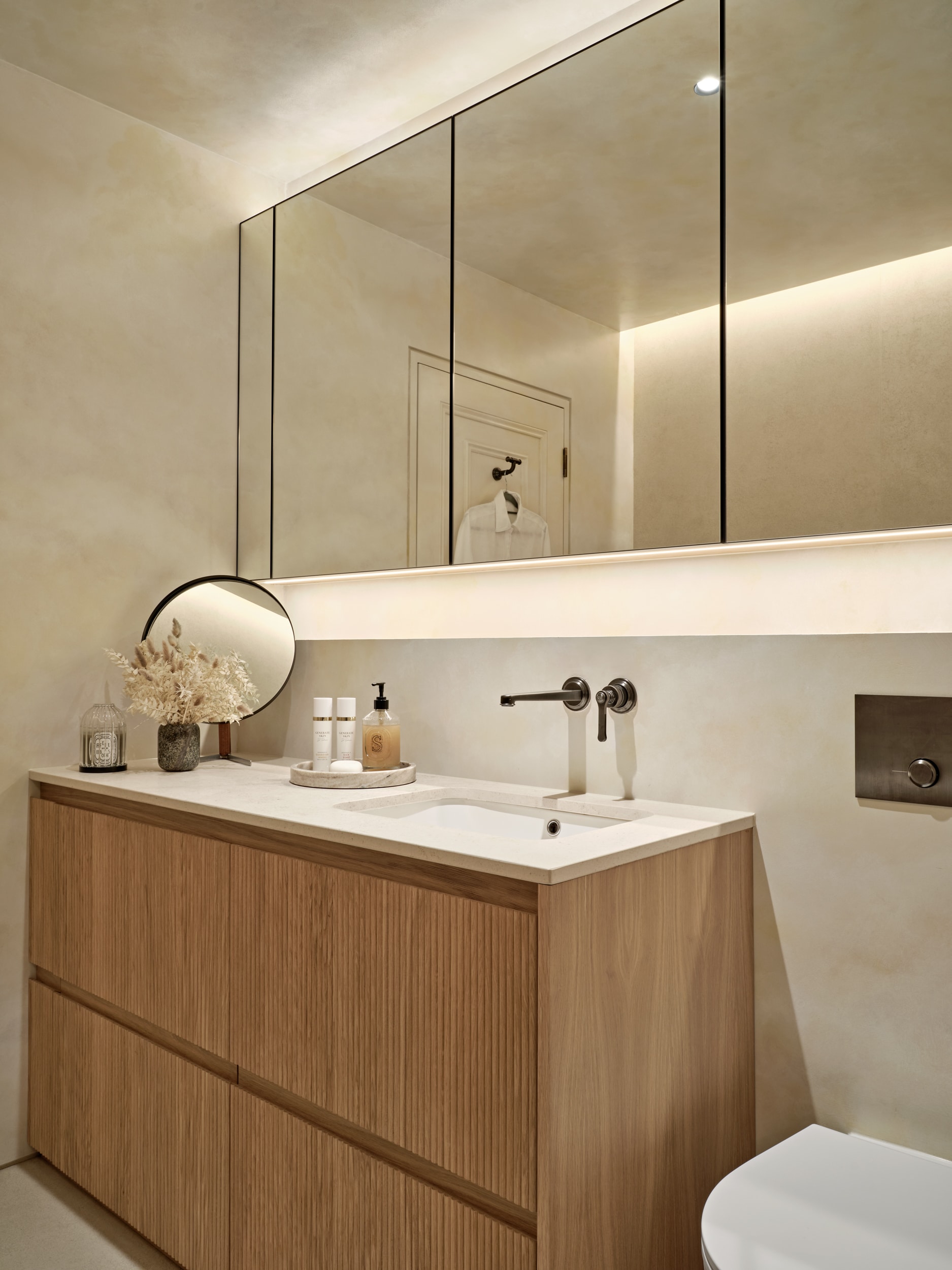 Counter and cabinetry in neutral relaxing bathroom.