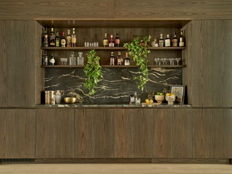 Luxury wooden and dark marble home bar.